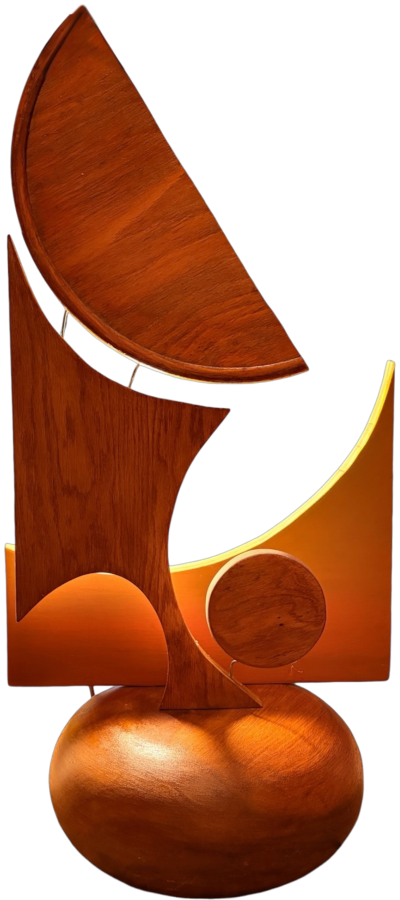 Balance, an abstract wood sculpture with a sail-like curved panel lit from behind, on a rounded wooden base
