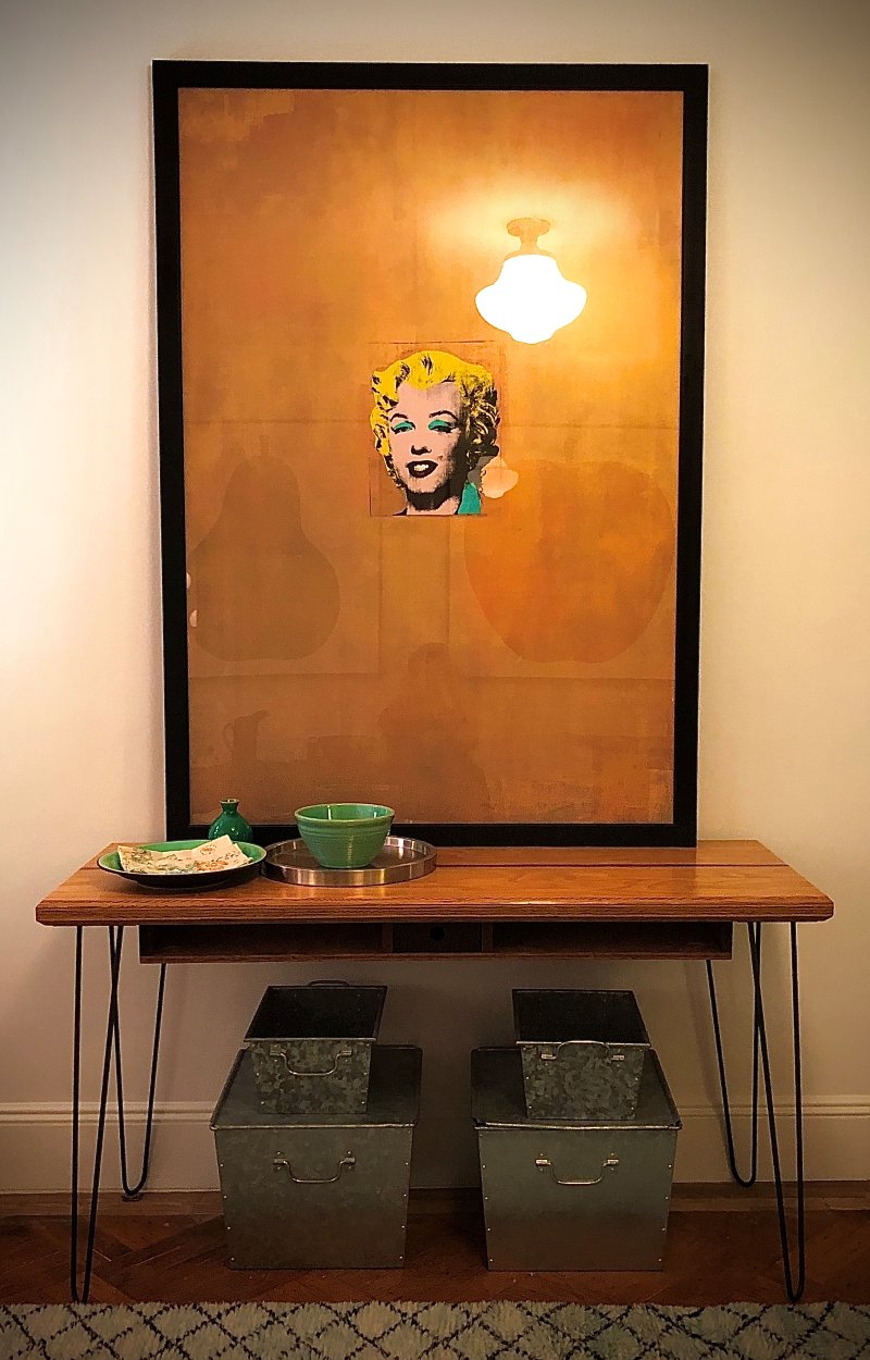 Pop-art Marilyn print above a hairpin-leg console with galvanized bins
