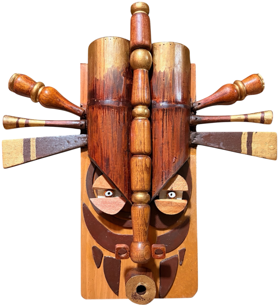 Guardian No. 1, The Keeper, a carved wooden face ringed by a radiating headdress of turned wood spindles, standing on a shelf